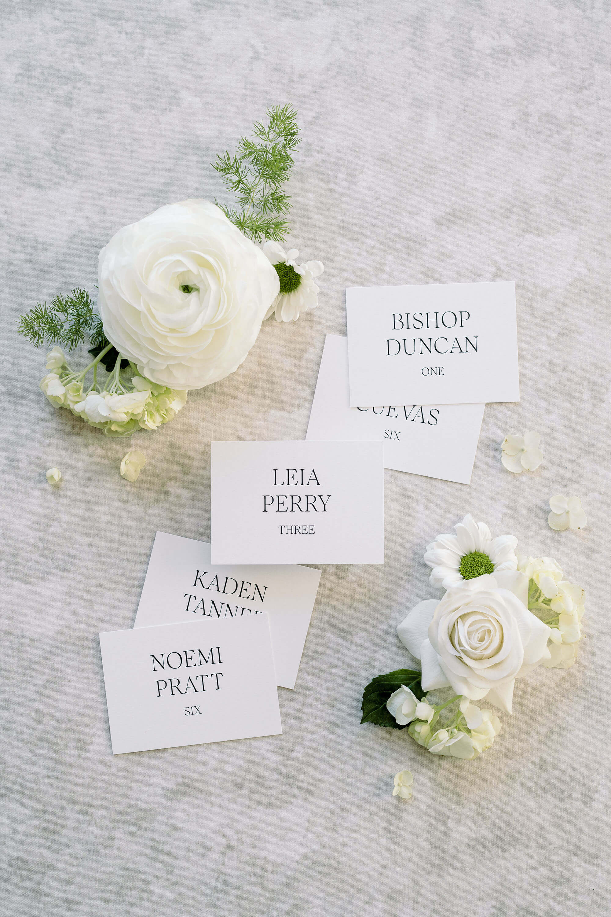 Modern wedding place cards with black text on white background