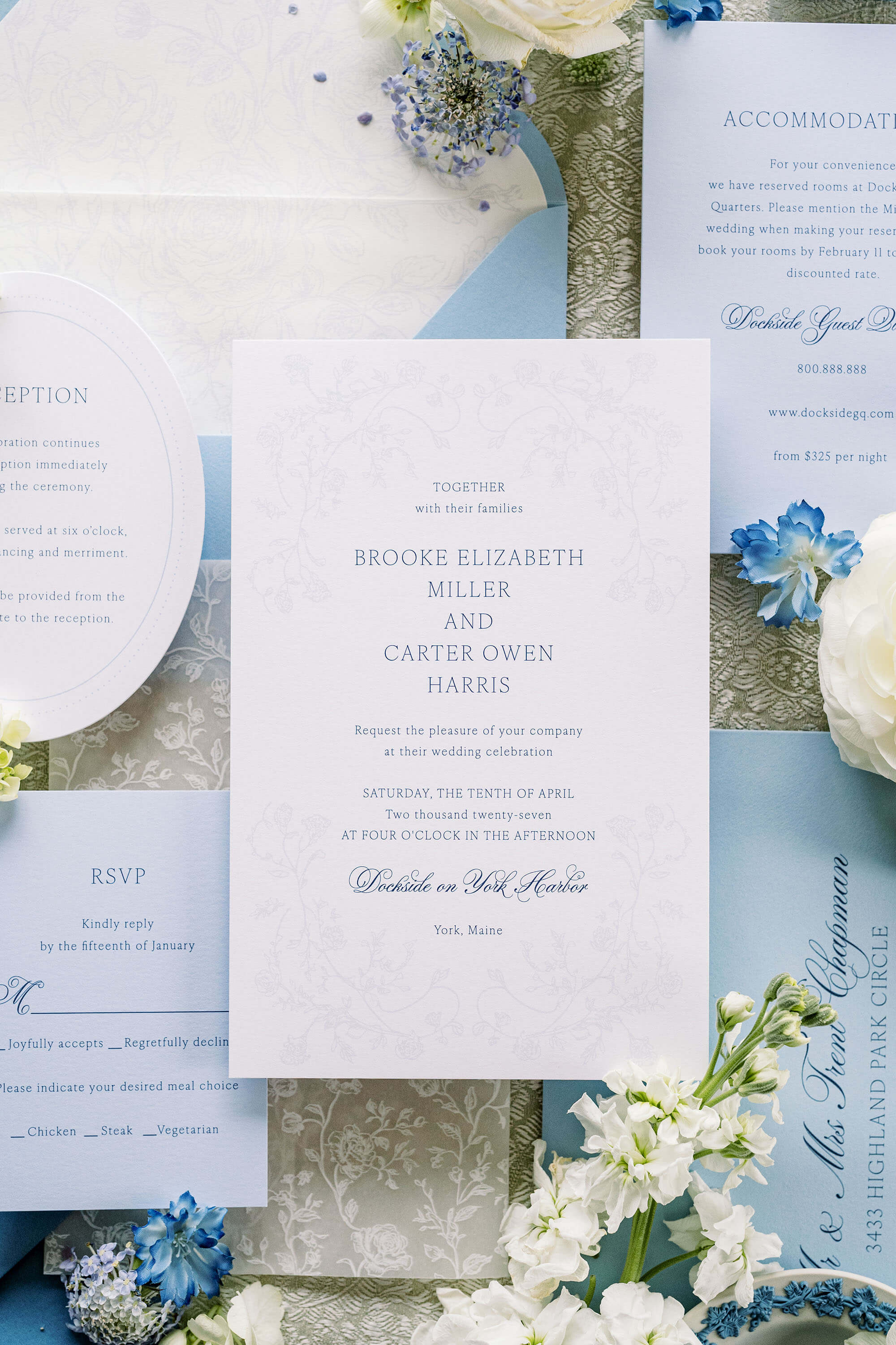 Blue and White Wedding invitation card with floral decorations on a light blue background