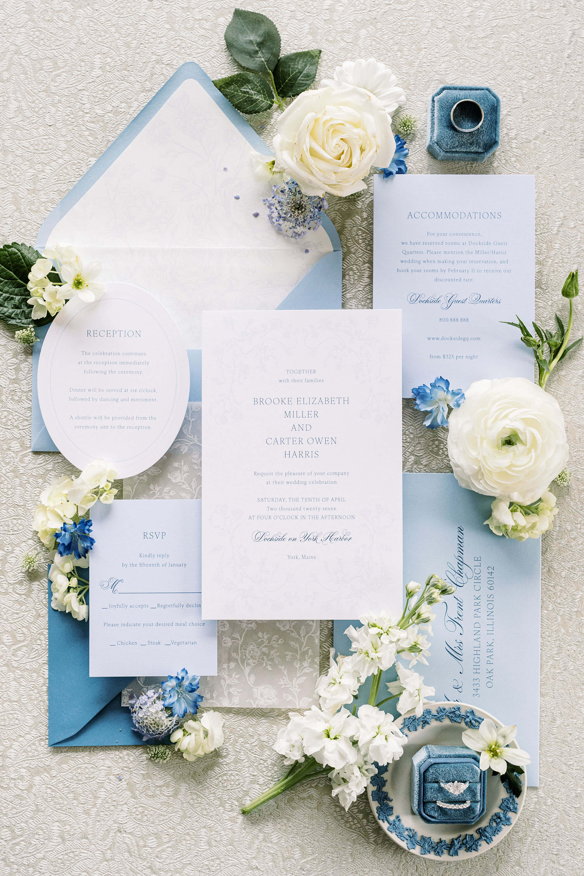 Blue Wedding invitation set with blue and white flowers on a textured surface