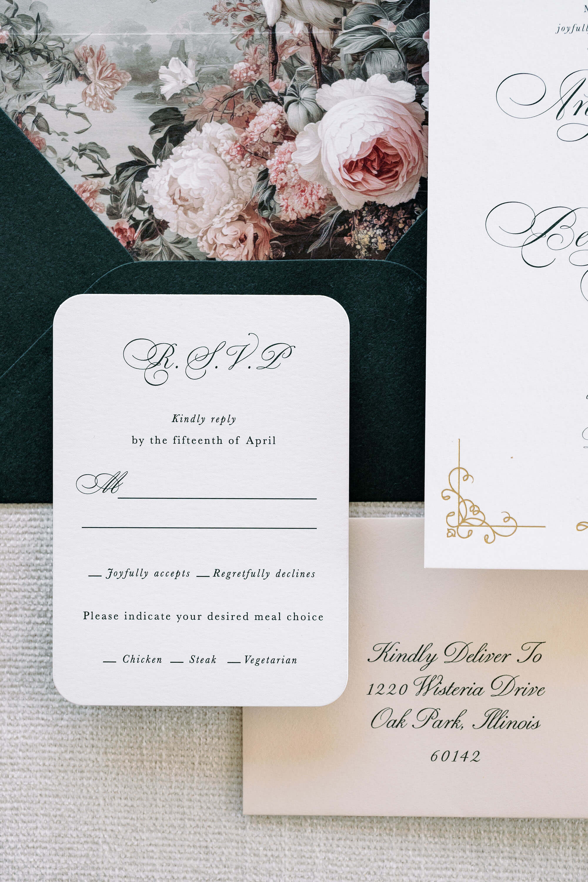 Wedding invitation card with floral design and RSVP card on a textured surface