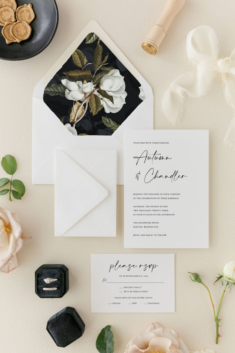 Minimalist wedding invitation with a floral envelope liner on a black background