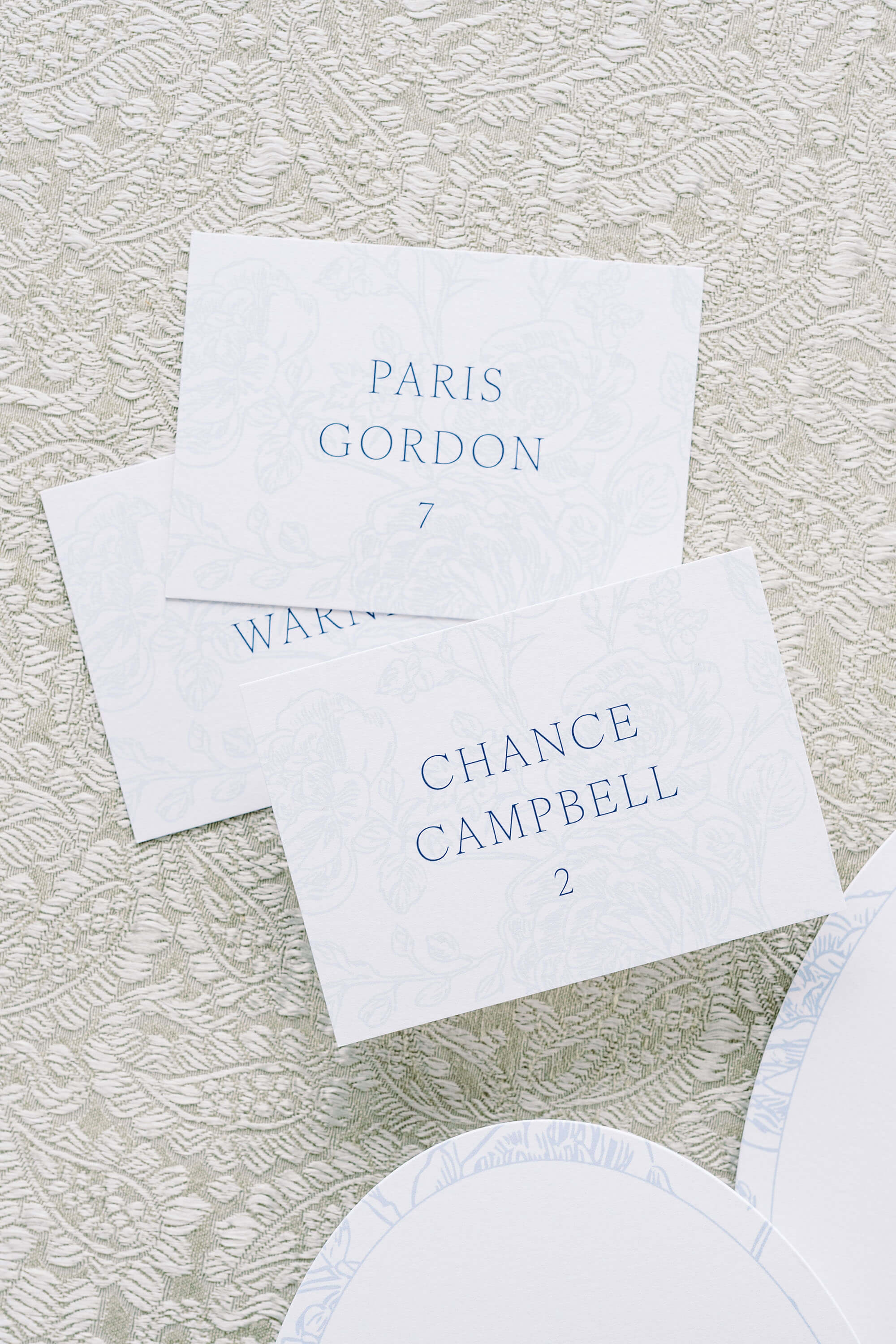 Elegant Wedding Place Cards with blue text and floral background