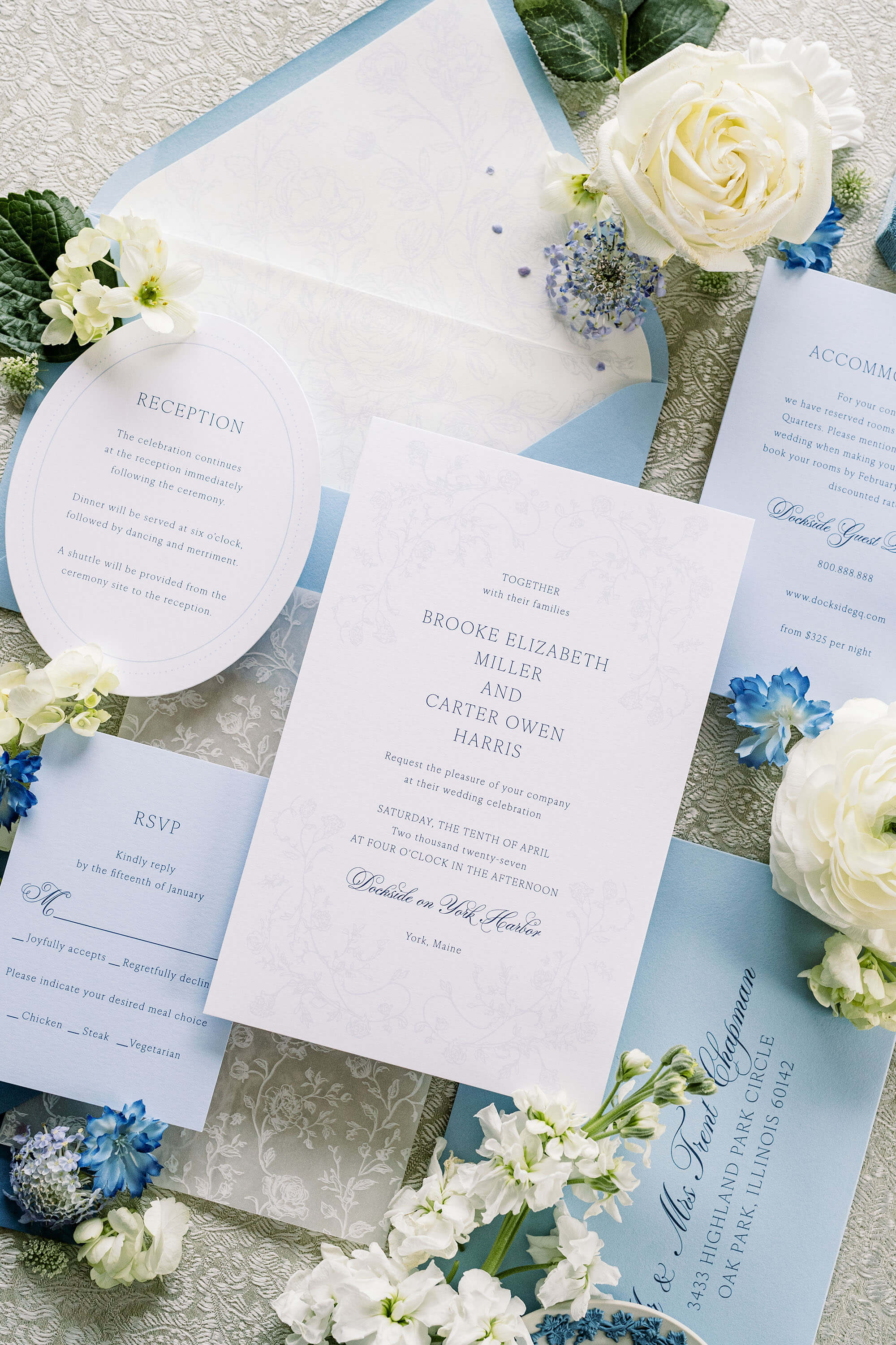 Wedding invitation set sample kit with white flowers on a textured surface